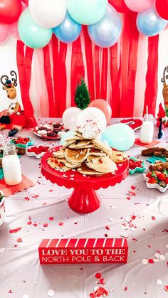 a table topped with lots of food and balloons