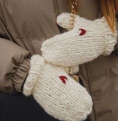 a close up of a person wearing a white knitted mitt with red lips