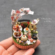 a miniature tea party is in someone's hand