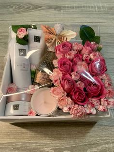 pink flowers and candles in a white box