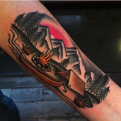 a man's arm with a boat and mountains on it