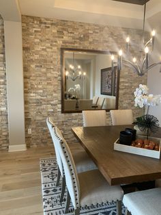 a dining room table with chairs and a mirror on the wall in front of it