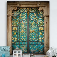 an old wooden door with blue and gold paint on the outside, in front of a white wall