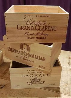 three wooden wine boxes stacked on top of each other, with labels in the bottom