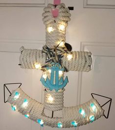 a cross made out of rope with lights on it and an anchor hanging from the side