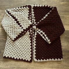 a brown and white crocheted dishcloth on top of a wooden table