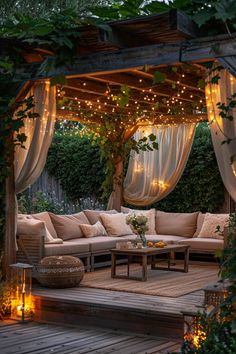 an outdoor living area with couches, tables and lights on the arbor above it