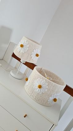 two lamps sitting on top of a white dresser