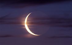 the crescent moon is seen in front of a cloudy sky