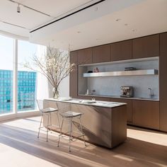 a modern kitchen with an island in the middle and two chairs at the counter top