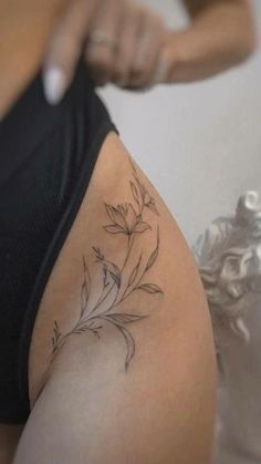 a woman with a flower tattoo on her thigh