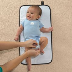 a baby laying on top of a mat with it's hands in the air