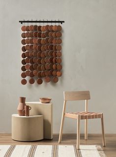 a chair and table in front of a wall with circles hanging on it's side