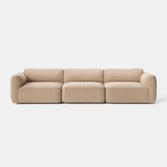 a beige couch sitting on top of a white floor