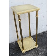 a white and gold side table with two legs