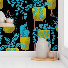 the wallpaper is decorated with blue and green plants on black background, along with two white vases