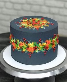 there is a cake decorated with leaves and berries on the top, surrounded by crayons