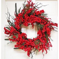 a red berry wreath hangs on the front door