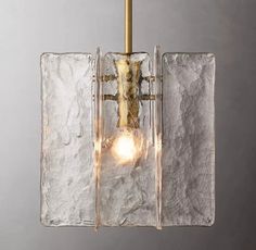 a glass and brass light fixture hanging from a metal ceiling lamp with two lights on each side