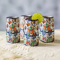 three colorful cups with a lime on top