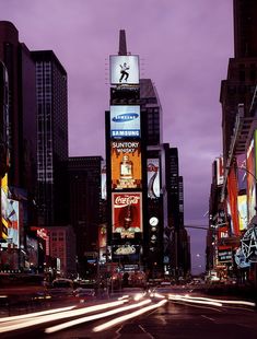 a city street filled with lots of tall buildings covered in neon signs and billboards