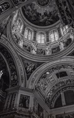 black and white photograph of the interior of a building with ornate paintings on the ceiling