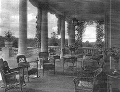 an old black and white photo of chairs in a room with columns on both sides