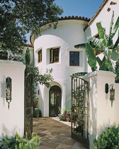 a white house with an iron gate in front