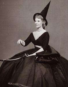 an old black and white photo of a woman in a witch costume