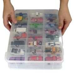 a person holding a plastic container filled with toy cars