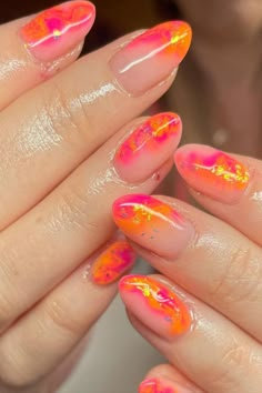 Embrace the warmth of summer with these almond-shaped nails boasting a vibrant interplay of pink and orange hues. Each nail features a unique marbled effect, swirled with vivid neon tones and accented by specks of golden glitter for a touch of sparkle. It's a playful and effervescent manicure that's perfect for making a bold statement. 🌞✨  // Photo Credit: Instagram @emsprettynails_ Pink Orange Glitter Nails, Orange And Pink Marble Nails, Pinky Orange Nails, Pink Orange Nails Summer, Pink And Orange Nail Art, Orange And Pink Nail Designs, Hot Pink And Orange Nails