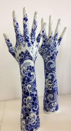 two blue and white hand vases sitting next to each other