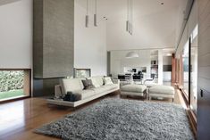 a modern living room with wood floors and white furniture