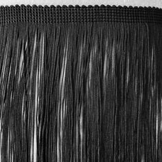 black and white photograph of fringes on a table cloth, taken from the bottom