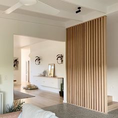 a living room with white walls and wooden slats