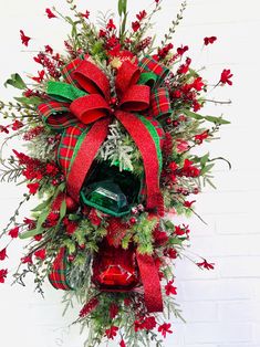 a christmas wreath hanging on the side of a building with red and green decorations around it