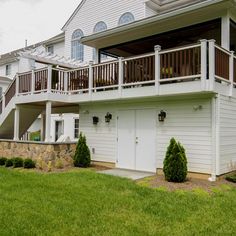 a white house with two balconies on the second floor and an attached deck