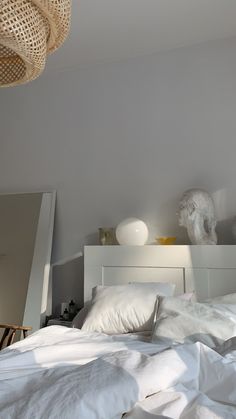 a bed with white sheets and pillows in a room