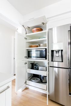 an open refrigerator freezer sitting inside of a kitchen