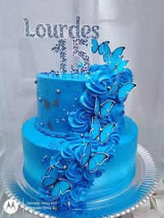 a blue cake with butterflies on it and the number thirteen is decorated in silver glitter