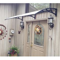 the front door of a house with two sunflowers hanging on it's side