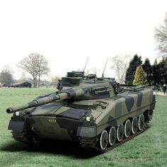 an army tank sitting on top of a lush green field