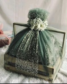 a green bag with flowers on it sitting on top of a white carpeted floor