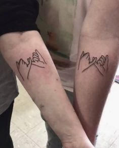 two people with matching tattoos on their arms