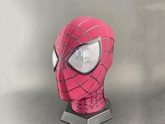 a pink spiderman mask on top of a metal stand