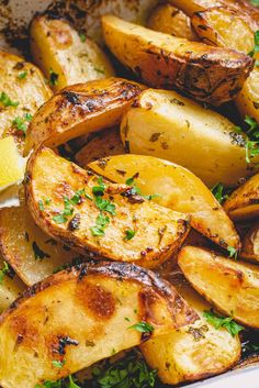 cooked potatoes with parsley and lemon in a white dish, ready to be eaten