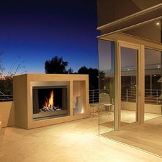 an outdoor fireplace is lit up at night