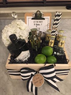 a gift basket with limes, bottles and other items in it on a table