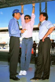 two men standing next to each other with their arms in the air and one man holding his hands up