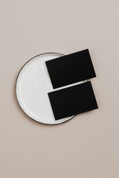 two pieces of black paper sitting on top of a white plate